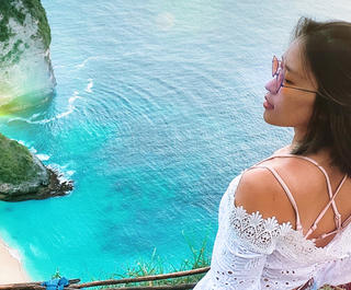 A woman looks across the sea on her Bali holiday, which she took via a cheap Bali Holiday package from Flight Centre.