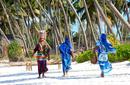 Local women walking along a beach, Zanzibar